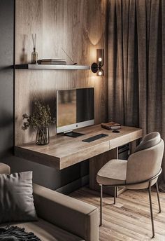 a desk with a computer on top of it in a living room next to a couch