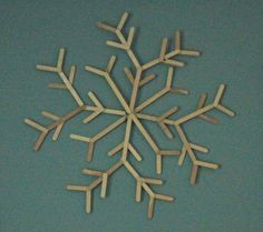 a snowflake made out of wood sticks on a blue background