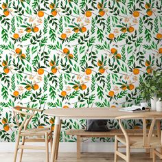 an orange and green wallpaper in a dining room with two wooden chairs next to a table