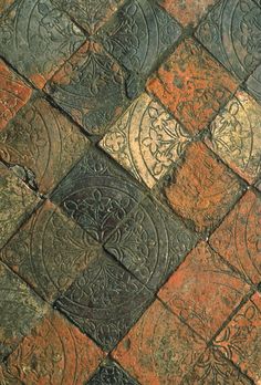 a close up view of an old tile floor with different colors and designs on it