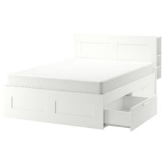 a white bed with drawers underneath it