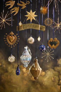 an assortment of christmas ornaments hanging from strings with ribbons and stars in the sky above them