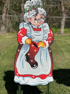 an image of a woman holding a christmas ornament on top of a lawn