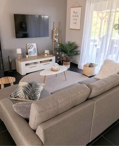 a living room filled with furniture and a flat screen tv mounted on the wall above it