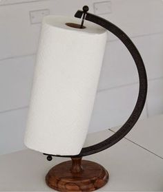 a white toilet paper roll on top of a wooden stand with a black ring around it