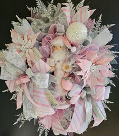 a pink and white wreath with a teddy bear