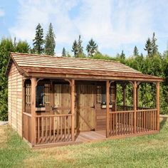 a small wooden shed sitting on top of a lush green field