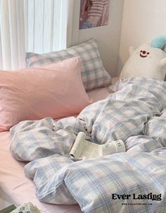 an unmade bed with pink and blue plaid comforter, pillows and stuffed animals