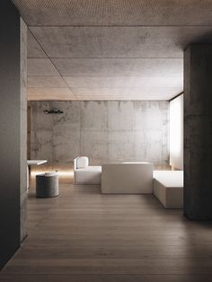 an empty room with concrete walls and white furniture