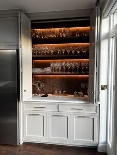 a cabinet with wine glasses on it in a kitchen