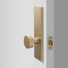 an open door with a handle and knob on it's side, in front of a white wall