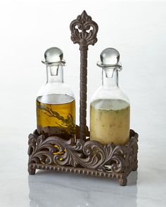 two bottles with soap in them sitting on a stand