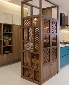 an open kitchen with blue cabinets and white flooring in the center is a large wooden screen