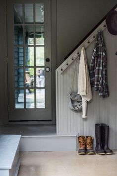 an image of the inside of a room with clothes hanging on hooks and coat racks