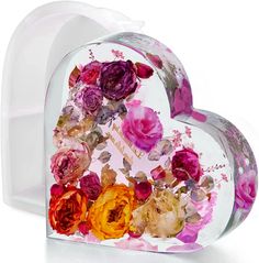 a heart shaped box filled with lots of flowers