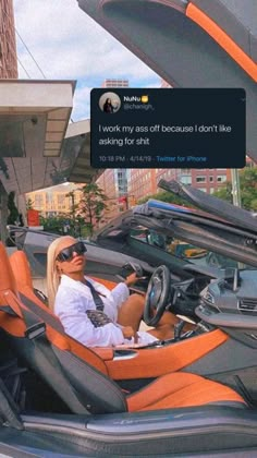 a woman sitting in the driver's seat of an orange and black sports car