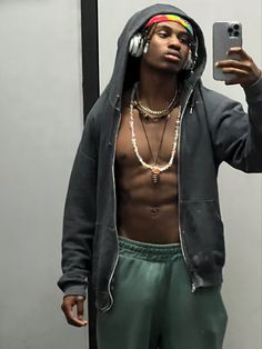 a man taking a selfie in front of a mirror wearing headphones and holding a cell phone