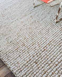 a white rug on the floor with a red chair