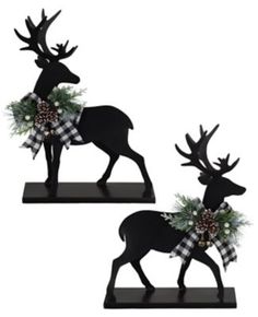 two black deer statues with christmas wreaths on their antlers