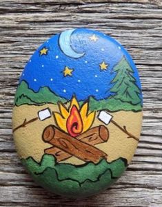 a painted rock with a campfire on it