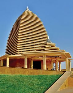 a large wooden structure sitting on top of a lush green field