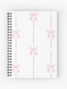 a spiral notebook with pink bows on it