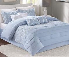 a bed with blue and white comforters in a room