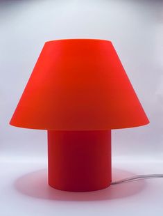 a red lamp sitting on top of a white table