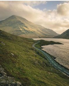 a scenic view of the road and water from above, with mountains in the background