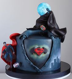 a cake decorated to look like batman and superman's shield with the moon in the background