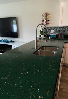 a green counter top in a kitchen next to a tv