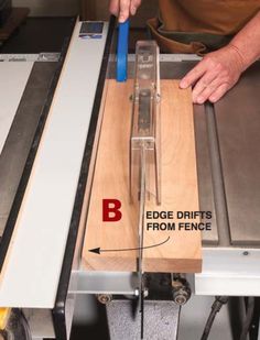 a person using a table saw to cut planks with a blue handle on it