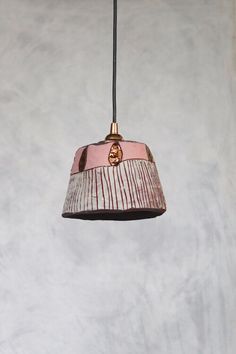 a pink and white lamp hanging from a ceiling