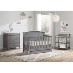 a baby's room with two dressers and a crib