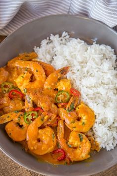 a bowl filled with rice and shrimp on top of a wooden table