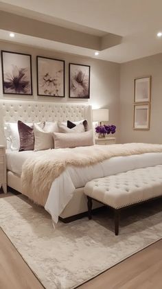 a large white bed sitting in a bedroom on top of a hard wood flooring