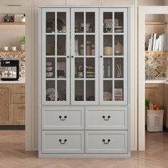 a white china cabinet with glass doors in a kitchen