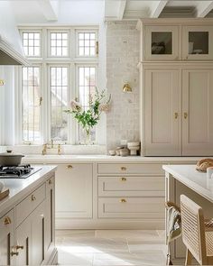 a white kitchen with lots of counter space and cabinets on both sides of the window