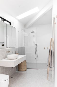 a bathroom with a toilet, sink and standup shower in the middle of it