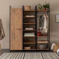 an open closet with clothes hanging on the rack and other items sitting on top of it