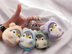 several small stuffed animals are being held by someone's hand