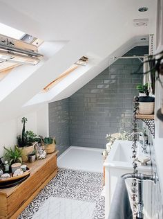 an attic bathroom with tiled floors and skylights above the bathtub is shown in this image