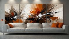 an orange and white painting on a wall above a couch in a room with grey walls