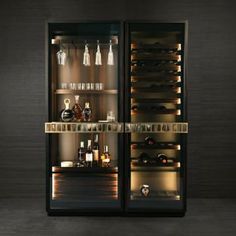 an open wine cabinet with bottles and glasses in the door, lit up at night