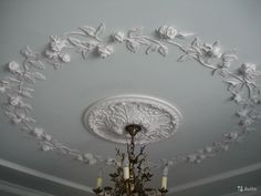 a chandelier hanging from the ceiling in a room with white walls and ceilings