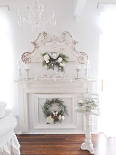 a white fireplace with wreaths and flowers on it