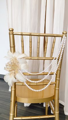 a gold chair with pearls and a flower on it