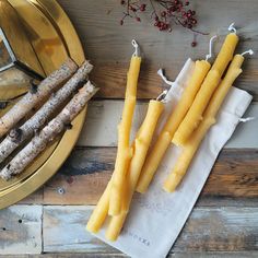 some yellow candles sitting on top of a wooden table next to a mirror and other items