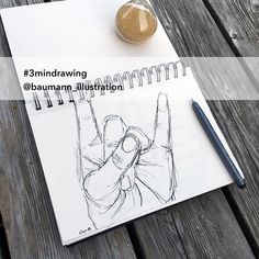 a notepad with a drawing of a hand holding a rock on top of it