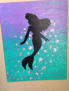 the silhouette of a mermaid is painted on a purple and blue background with silver glitters